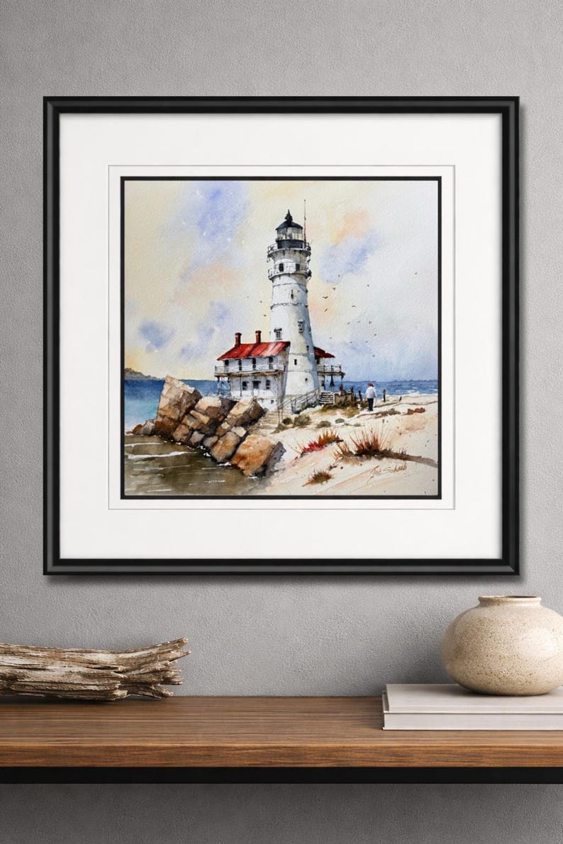 K&ouml;nnte beinhalten: Aquarellmalerei eines wei&szlig;en Leuchtturms mit schwarzem Dach und rotem Dach, an einer felsigen K&uuml;ste gelegen. Das Kunstwerk ist schwarz gerahmt und zeigt eine ruhige K&uuml;stenlandschaft mit blauem Wasser und einem Sandstrand.