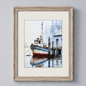 May include: A framed watercolor painting depicting a blue and white fishing boat moored at a wooden dock next to a small shed. The scene features a misty background with evergreen trees, a seagull on a post, and a reflection in the water.