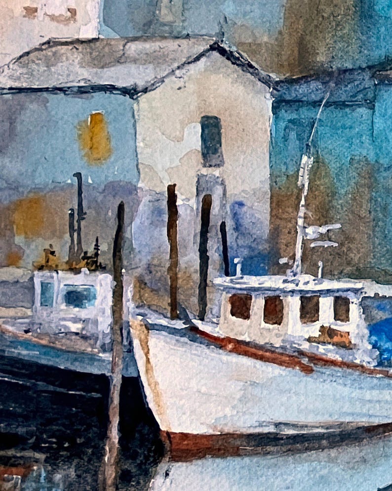 May include: Watercolor painting of a harbor scene with two white boats docked near buildings. The boats have brown accents and are reflected in the water. The buildings are light blue and beige with dark roofs.