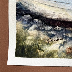 May include: Watercolor painting of a boat on a rocky shore. The boat has a red stripe along the top edge. The artist's signature, "Joe Schaub", is visible in the lower right corner. The painting is on textured paper.