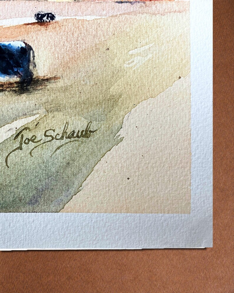 May include: Watercolor painting with a landscape theme. The artwork features a signature in the lower left corner, "Joe Schaub". The painting has a soft color palette with shades of blue, beige, and green.