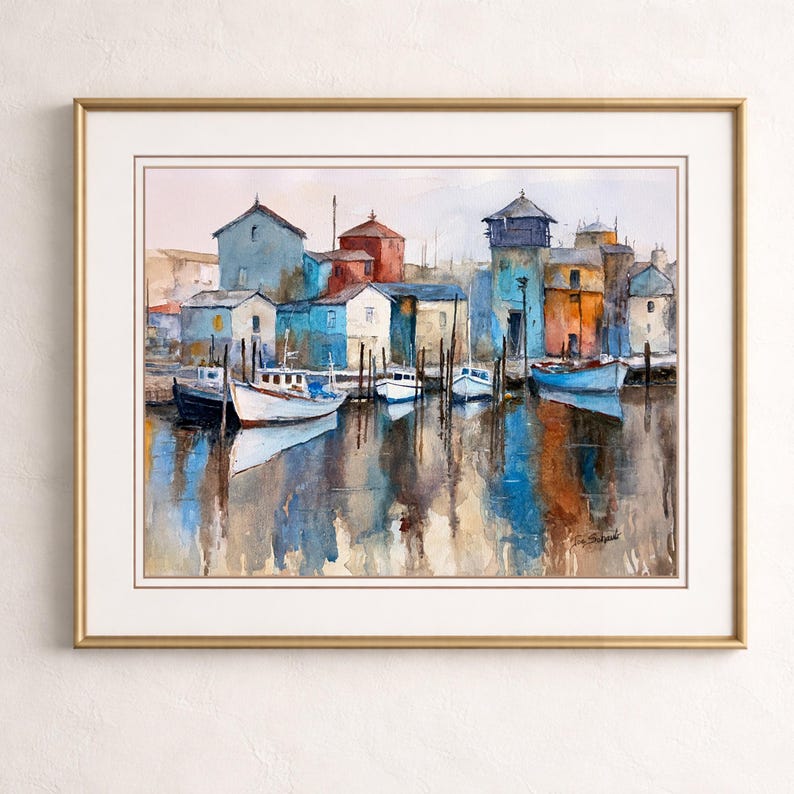 May include: Watercolor painting of a harbor scene with boats docked near colorful buildings. The artwork features a gold frame and a serene reflection of the buildings and boats in the water, with a signature in the bottom right corner.