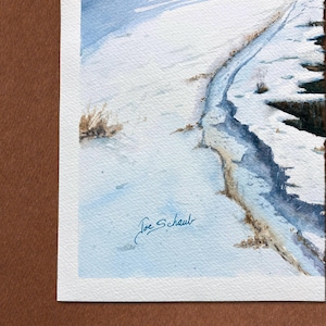 K&ouml;nnte beinhalten: Aquarellmalerei einer verschneiten Landschaft mit einem gewundenen Pfad. Das Kunstwerk zeigt Blau- und Wei&szlig;t&ouml;ne, die eine Winterszene darstellen. Unten rechts signiert mit "Joe Schaub".