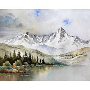 May include: A watercolor painting depicting a serene mountain landscape with snow-capped peaks rising above a calm lake. Dark green pine trees line the shore in the foreground, while soft blue and gray clouds drift across the sky above the mountains.