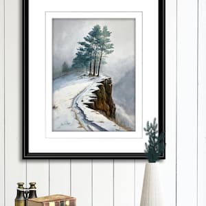 K&ouml;nnte beinhalten: Aquarellmalerei eines schneebedeckten Klippenrandes mit immergr&uuml;nen B&auml;umen. Das Kunstwerk ist in einem schwarzen Rahmen gerahmt und wei&szlig; mattiert. Das Gem&auml;lde zeigt eine Winterlandschaft mit einem Pfad entlang der Klippe.