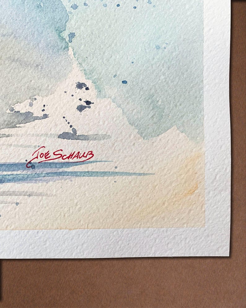 May include: Watercolor painting with soft blue, gray, and beige hues. The artwork features abstract shapes and splatters, with the artist's signature, "Joe Schaub," in red ink at the bottom. The painting is on textured watercolor paper.
