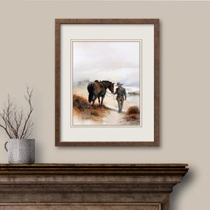 May include: Watercolor painting of a cowboy leading a horse on a path. The artwork is framed in a dark brown wooden frame with a white mat. The scene depicts a serene outdoor setting with muted colors.