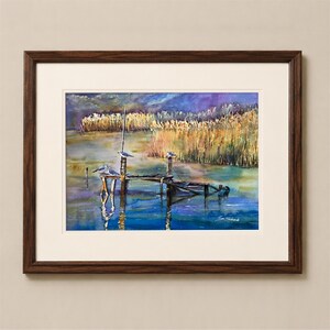 Puede incluir: Una pintura en acuarela enmarcada que representa un muelle de madera desgastado sobre aguas tranquilas, con varias aves posadas en los postes. Juncos dorados bordean el fondo bajo un cielo azul y violeta, con una firma en la esquina.