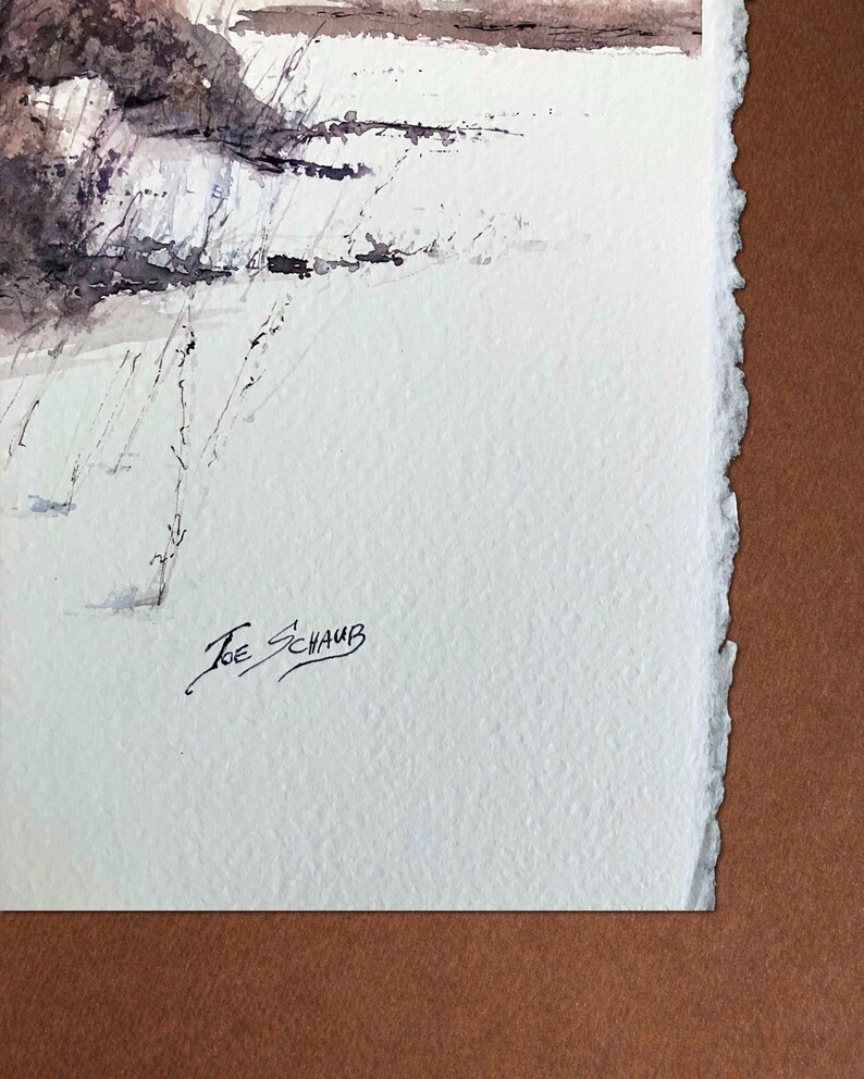 May include: A watercolour landscape painting depicting a snowy field and trees, with shades of brown, purple, and white. The artist's signature, "Joe Schaub," is in the lower left. The paper has a deckled edge, giving it a textured appearance.