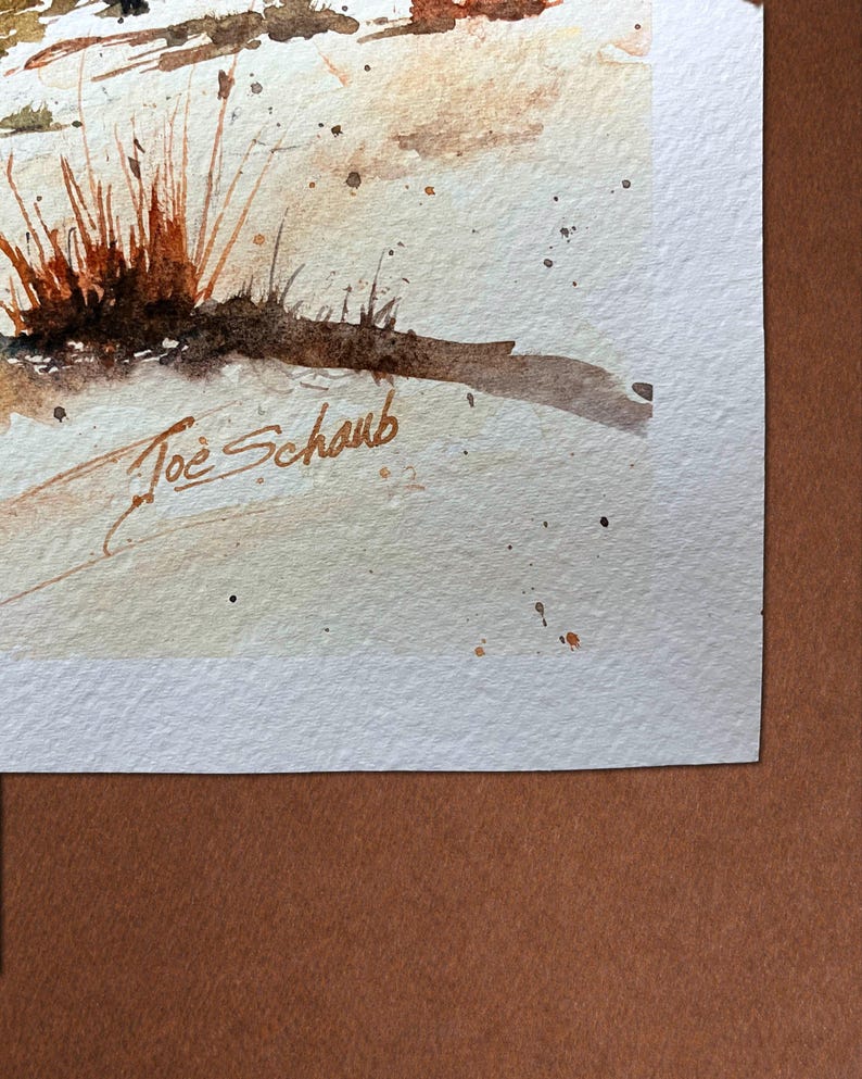 K&ouml;nnte beinhalten: Aquarellmalerei mit einer Nahaufnahme von trockenem Gras in Braun- und Oranget&ouml;nen. Das Kunstwerk hat ein weiches, strukturiertes Aussehen mit subtilen Farbspritzern. Die Signatur des K&uuml;nstlers, "Joe Schaub", ist unten links zu sehen.