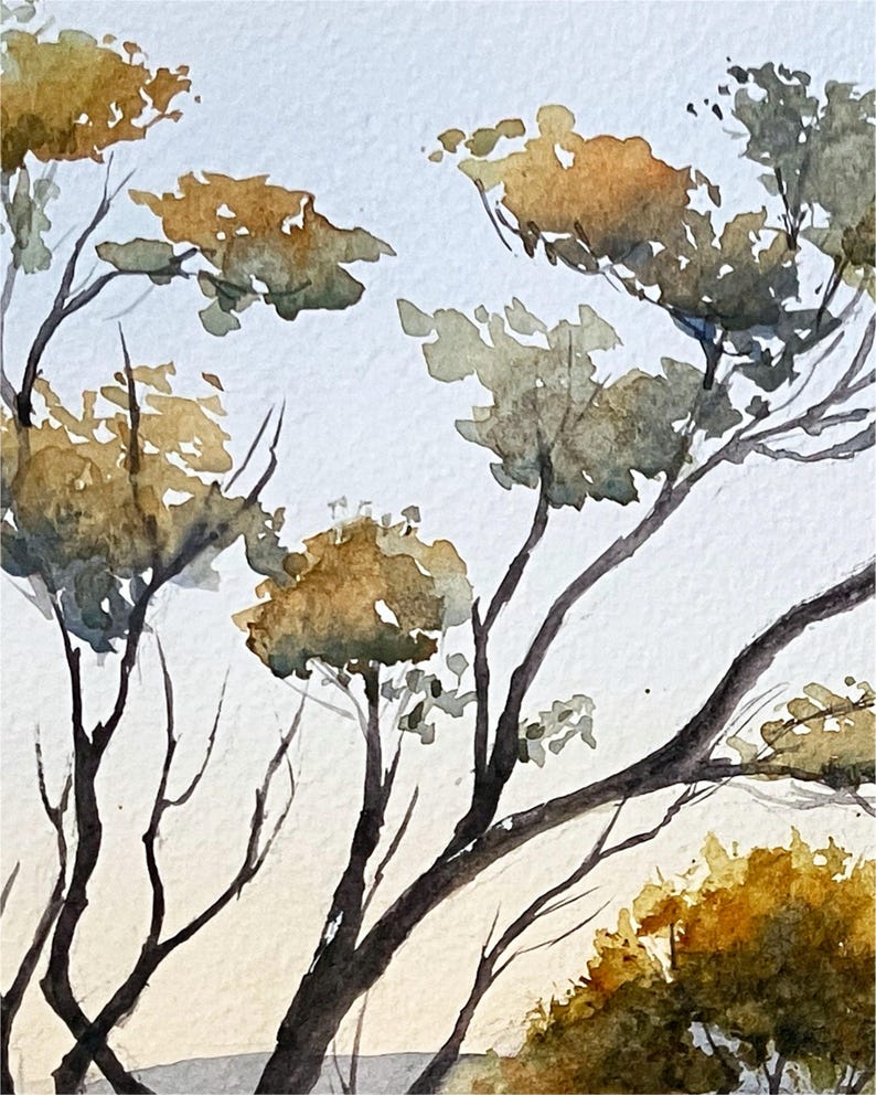 May include: Watercolor painting of tree branches with olive green and golden leaves against a light blue and cream background. The artwork depicts a natural landscape with a soft, artistic style.