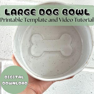 Puede incluir: Un cuenco para perros de cerámica blanca moteada con un diseño en forma de hueso en el centro. El cuenco está etiquetado como "LARGE DOG BOWL" y "DESCARGA DIGITAL".