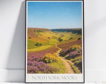 Może przedstawiać: Oprawiony wydruk krajobrazu North York Moors. Obraz przedstawia krętą ścieżkę przez dolinę pełną fioletowych i żółtych dzikich kwiatów. Niebo jest błękitne, a wydruk jest oprawiony w czarną ramę, z napisem 'NORTH YORK MOORS'.