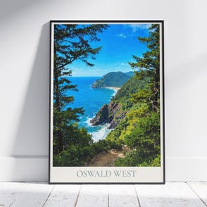 Peut inclure: Une affiche encadrée d'un paysage côtier avec une mer bleu vif, des arbres verts luxuriants et une plage de sable. L'œuvre est intitulée "OSWALD WEST" en gris clair en bas.