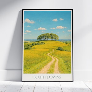 Peut inclure: Une affiche encadrée représentant un paysage rural. Un chemin sinueux traverse un champ jaune jusqu'à une colline boisée, sous un ciel bleu nuageux. Le texte "SOUTH DOWNS" est en bas de l'affiche.