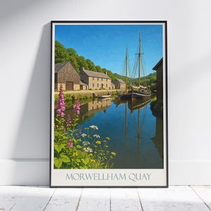 May include: Framed print of Morwellham Quay, featuring a serene canal scene with a sailboat, historic buildings, and vibrant flowers. The artwork captures a sunny day with clear reflections in the water, and the text "MORWELLHAM QUAY" at the bottom.