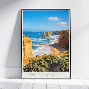 以下が含まれることがあります： オーストラリアの海岸沿いにある十二使徒岩の風景写真のフレームプリント。明るい青い空、ターコイズブルーの海、黄金色の崖が特徴です。「TWELVE APOSTLES」の文字が画像の下部に印刷されています。