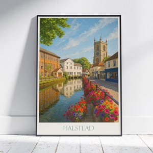 Puede incluir: Una impresión enmarcada de Halstead, con un canal con flores coloridas, edificios históricos y una torre de iglesia bajo un cielo azul. La palabra "HALSTEAD" está impresa en la parte inferior de la imagen.