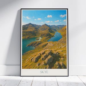 Könnte beinhalten: Gerahmter Landschaftsdruck mit einer malerischen Aussicht auf Berge, einen See und einen blauen Himmel mit Wolken. Der Druck hat einen weißen Rand und das Wort "SKYE" ist unten aufgedruckt.