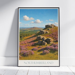 Op de afbeelding: Een ingelijste landschapsafdruk van Northumberland, met een levendige heuvel bedekt met paarse heide en rotsachtige ontsluitingen onder een blauwe lucht met pluizige wolken. De afdruk heeft het woord "NORTHUMBERLAND" onderaan.