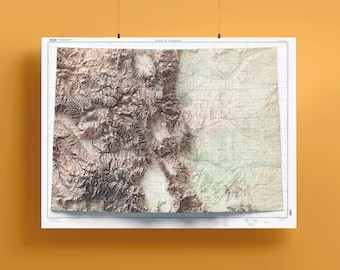 May include: A topographic map of the state of Colorado, showing the elevation of the land with brown, green, and white colors. The map is printed on white paper and is hanging from a string.