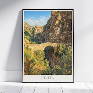 May include: A framed art print depicting Civita, Italy. The image shows a stone bridge spanning a gorge, with a village visible in the distance. The print is in a black frame and is displayed on a white wall. The text "CIVITA" is at the bottom.