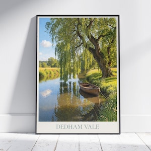 Puede incluir: Una impresión enmarcada de una serena escena fluvial. Un pequeño bote de madera está amarrado cerca de la orilla, bajo un gran sauce llorón. El agua refleja el cielo y la vegetación circundante. El texto "DEDHAM VALE" está impreso en la parte inferior.