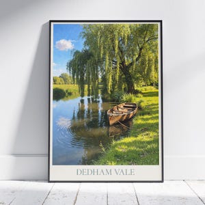 Puede incluir: Un cuadro enmarcado de un paisaje sereno con una barca de madera en un río tranquilo. La escena incluye un sauce llorón, hierba verde exuberante y un cielo azul con nubes. El texto "DEDHAM VALE" está en la parte inferior.
