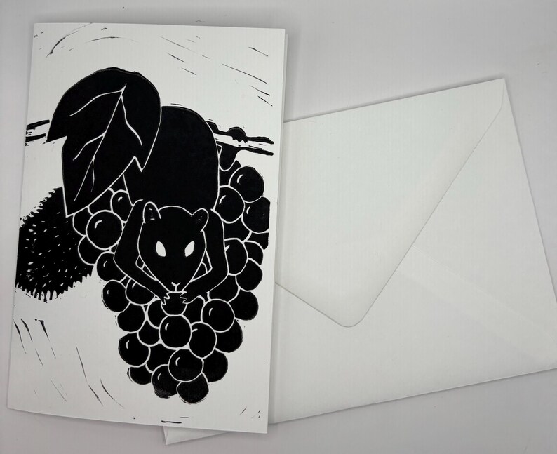 May include: Black and white art print of a rodent eating grapes. The illustration is on a white card with a matching white envelope. The design features a stylized depiction of a mouse or rat amidst a cluster of grapes.