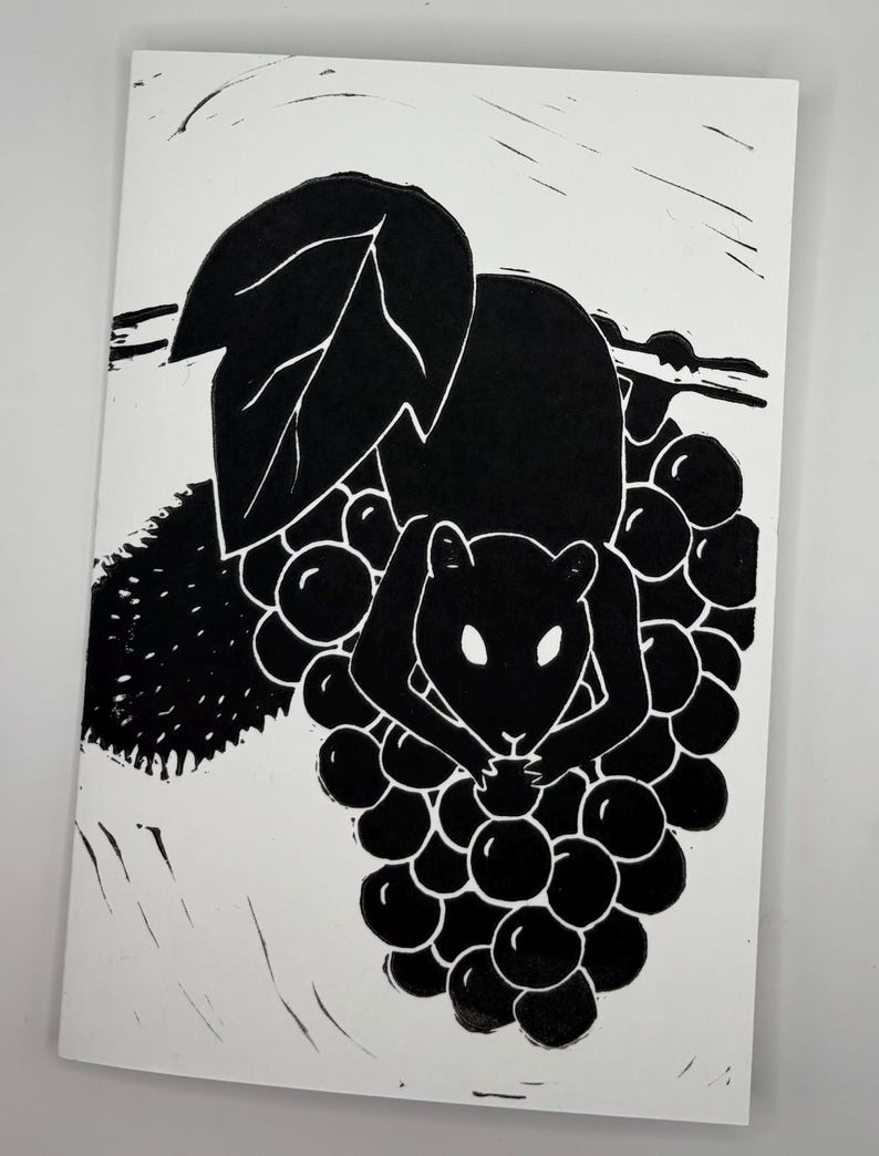 May include: Black and white linocut print of a squirrel perched on a bunch of grapes. The squirrel is depicted in silhouette, holding a grape. A large leaf and vine are also visible.