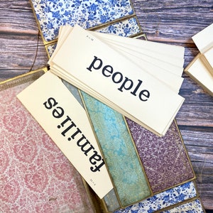 May include: Two cream-colored index cards with black text. The top card reads "people" and the bottom card reads "families".