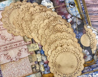 May include: A stack of 10 brown paper doilies with scalloped edges. The doilies are arranged in a circular pattern and have a delicate lace design.