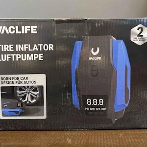 Peut inclure: Inflateur de pneus VACLIFE noir et bleu avec un écran numérique affichant 8.8.8 PSI. La boîte indique "TIRE INFLATOR LUFTPUMPE" et "BORN FOR CAR DESIGN FÜR AUTOS". Garantie de 2 ans.