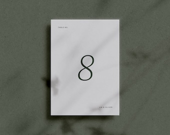 May include: White card with black text that reads "Table No. 8" and "Lia & Oliver" at the bottom.