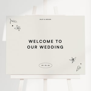 Puede incluir: Un cartel de bienvenida de boda blanco con texto negro que dice "Riley & Archer" y "Bienvenido a nuestra boda" con la fecha "09-18-26". El cartel está decorado con simples dibujos de línea negra de flores y hojas.