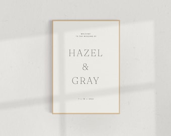 May include: A framed wedding announcement with a white background and black text. It says "Welcome to the wedding of Hazel & Gray 7-18-2022".