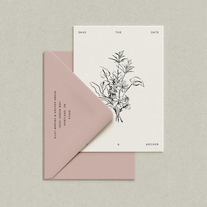 May include: A white card with black text that reads "Save the Date" and features a black and white line drawing of a bouquet of flowers. The card is partially covered by a pink envelope with black text that reads "Riley Marino & Archer Green, 14021 Heron Way, Portland, OR 97205".