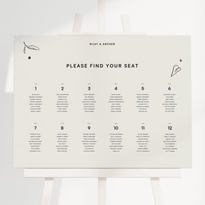 Puede incluir: Un plano de asientos beige con texto negro y dibujos simples de hojas y un corazón. El plano de asientos está titulado "Riley & Archer" y "Por favor, encuentre su asiento". El plano de asientos enumera 12 mesas con los nombres de los invitados.
