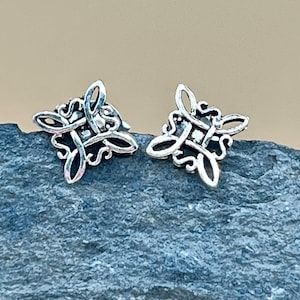 May include: A pair of silver Celtic knot earrings. The earrings are in the shape of a square with a knot design in the center.