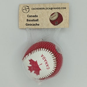 May include: A red and white baseball with a Canadian maple leaf and the word "CANADA" printed on it. The baseball is in a clear plastic bag with a brown tag that says "CACHEWORLDCA@YAHOO.COM", "Canada Baseball Geocaching".