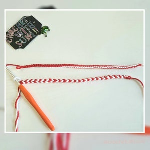 May include: A close-up of a red and white crocheted bracelet with a crochet hook and white yarn. The bracelet is on a white surface. The text "Crochet with SUMI!" is visible on a black tag.