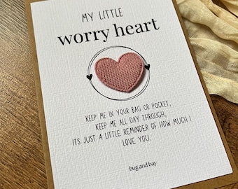 May include: A greeting card with the text "MY LITTLE worry heart" and a pink heart. The card includes the message "KEEP ME IN YOUR BAG OR POCKET, KEEP ME ALL DAY THROUGH, ITS JUST A LITTLE REMINDER OF HOW MUCH I LOVE YOU." The brand name "bug and bay" is at the bottom.