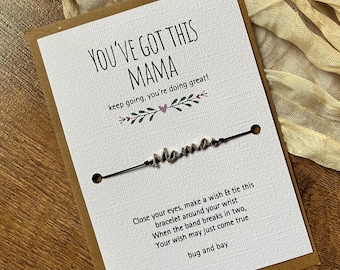 May include: A greeting card with the text "YOU'VE GOT THIS MAMA" and a bracelet. The card has a brown border and includes the text "keep going, you're doing great!". The bracelet says "Mama".