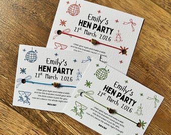 May include: Three white cards with text and illustrations for a hen party. Each card has a different colored string attached. The text reads "Emily's HEN PARTY 21st March 2026" with additional text and illustrations of a disco ball, bows, and champagne glasses.