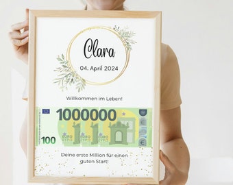 May include: A framed print with a gold circle and green leaves, the text "Clara" and "04. April 2024" inside the circle. The text "Willkommen im Leben!" is below the circle. A stylized image of a 100 Euro bill with the text "1000000" is below the text. The text "Deine erste Million für einen guten Start!" is below the bill.