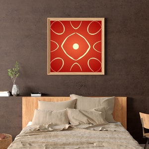 Puede incluir: Una impresión de arte abstracto enmarcada con fondo rojo y formas geométricas blancas. La impresión está colgada en una pared marrón sobre una cama con sábanas beige.