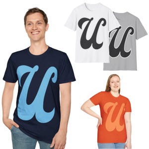May include: Three t-shirts with a stylized "U" graphic in different colors. The first shirt is white with a black "U", the second is gray with a black "U", and the third is navy blue with a light blue "U".