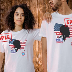 Puede incluir: Dos camisetas blancas con un diseño del Mes de la Historia Negra. El diseño presenta una silueta de perfil, la bandera estadounidense y las palabras "Black History Month". Las camisetas las llevan dos personas.