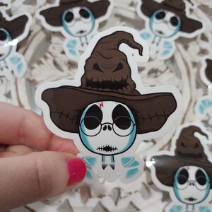 May include: A sticker featuring a cartoon character with a brown wizard hat and round glasses. The character has a white face, black stitched mouth, and light blue accents. Several stickers are visible.