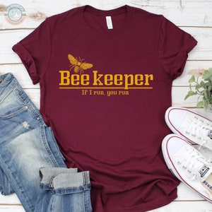 May include: A maroon t-shirt with a bee graphic and the text "Bee Keeper If I run, you run".